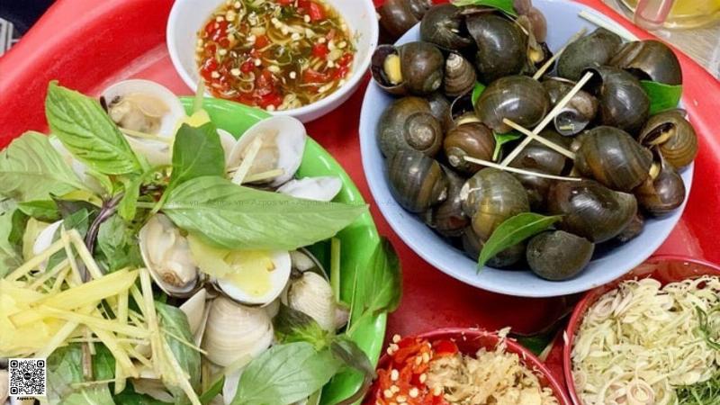 Quán ốc vỉa hè đông khách, không khí nhộn nhịp, thể hiện địa điểm ăn ốc ngon gần đây được nhiều người ưa chuộng
